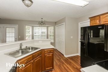 Charlotte house for rent - a kitchen with a sink and a black refrigerator