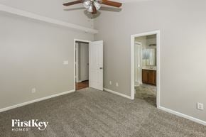 Charlotte house for rent - a bedroom with a carpeted floor and a ceiling fan