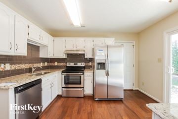 Charlotte house for rent - a kitchen with white cabinets and stainless steel appliances