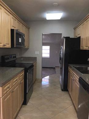 Hollywood house for rent - a kitchen with black appliances and wooden cabinets