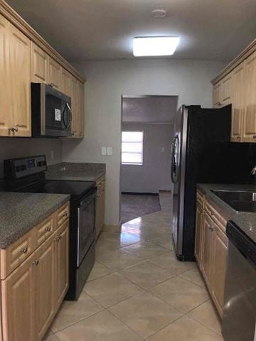 Hollywood house for rent - a kitchen with black appliances and wooden cabinets