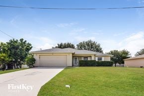 Cape Coral house for rent - a suburban house with a lawn and a driveway