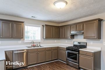 Grayson house for rent - a kitchen with wooden cabinets and stainless steel appliances