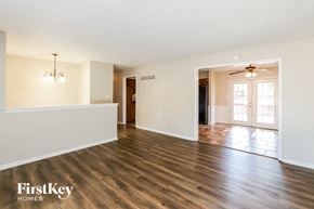 Lee's Summit house for rent - an empty living room and dining room with wood flooring
