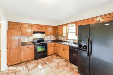 Lee's Summit house for rent - a kitchen with black appliances and wooden cabinets