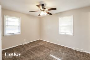 Lee's Summit house for rent - a bedroom with a ceiling fan and two windows