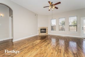 Lancaster house for rent - A spacious room with a fireplace and a ceiling fan.