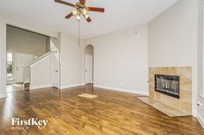 Lancaster house for rent - A spacious living room with a fireplace and a ceiling fan.