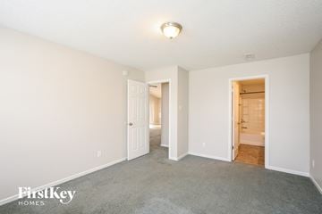 Noblesville house for rent - a spacious living room with carpet and a door to the bathroom