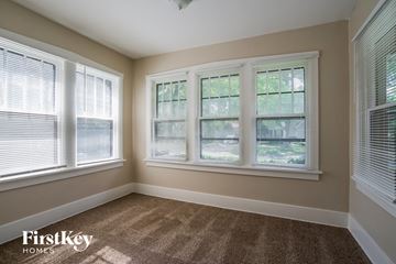 Waukegan house for rent - a living room with three windows and a carpet
