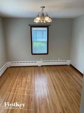 Joliet house for rent - an empty living room with wood floors and a window