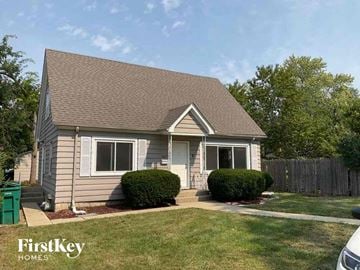 Joliet house for rent - a small tan house with a yard and a fence