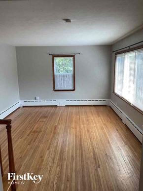 Joliet house for rent - an empty living room with wood floors and a window