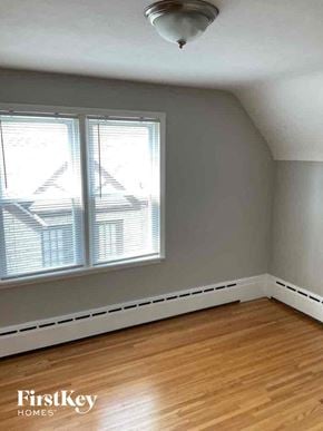 Joliet house for rent - an empty room with a wood floor and two windows