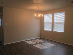 Cedar Hill house for rent - an empty living room with a chandelier and two windows