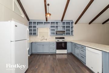 Birmingham house for rent - a kitchen with blue cabinets and white appliances and a white refrigerator