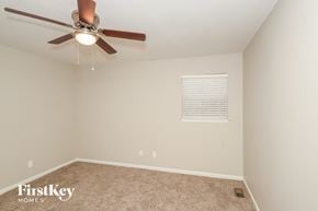 Birmingham house for rent - a bedroom with a ceiling fan and a carpeted floor