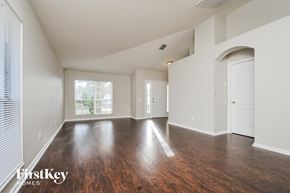Riverview house for rent - A spacious room with wooden floors and white walls, with a window on the left side.