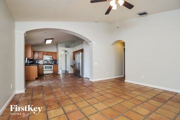 Riverview house for rent - A spacious kitchen and living room with a tile floor and a ceiling fan.
