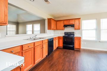 Houston house for rent - A kitchen with wooden cabinets and a black oven.