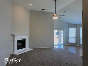 Crowley house for rent - a living room with a fireplace and a ceiling fan