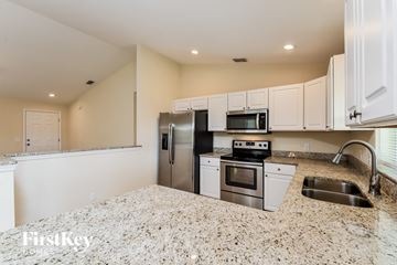 Port Charlotte house for rent - a kitchen with granite counter tops and stainless steel appliances