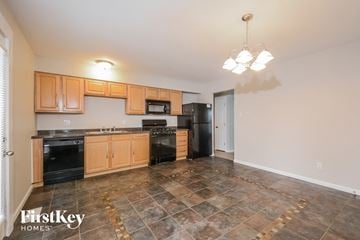 Saint Charles house for rent - A kitchen with brown cabinets and black appliances.