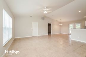 Port Charlotte house for rent - an empty living room with a ceiling fan and a window