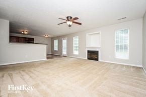 Covington house for rent - an empty living room with a ceiling fan and a fireplace