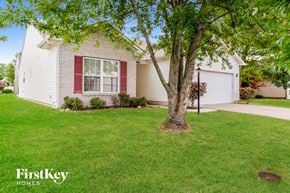 Fishers house for rent - a white house with red shutters and a tree in the yard
