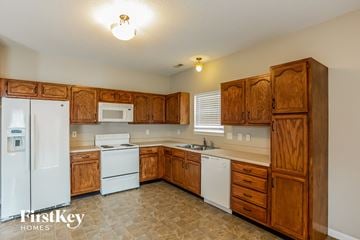 Fishers house for rent - a kitchen with white appliances and wooden cabinets