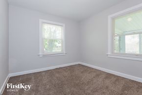 Saint Louis house for rent - a bedroom with a carpeted floor and two windows