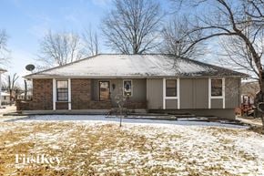 Kansas City house for rent - A house with a snow-covered roof and a snow-covered lawn.