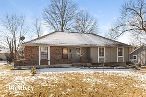 Kansas City house for rent - A house with a snow-covered roof and bare trees in the background.
