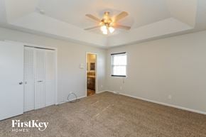 Kansas City house for rent - A spacious room with a ceiling fan and carpeted floor.