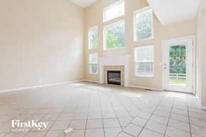 Batavia house for rent - A spacious room with a fireplace and large windows.