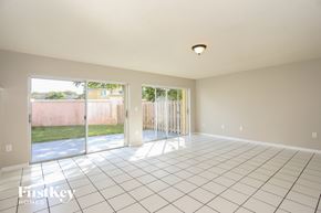 Miami house for rent - A large empty room with a tiled floor and sliding glass doors.