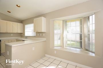 Miami house for rent - A kitchen with white cabinets and a white counter top.