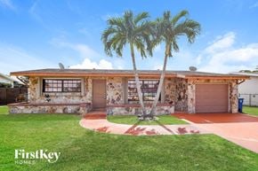 Sunrise house for rent - a home with two palm trees in front of it