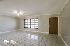 Sunrise house for rent - an empty living room with tiled floors and a window