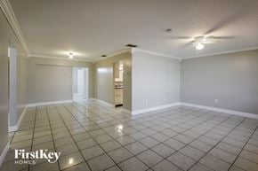 Sunrise house for rent - an empty living room with tile flooring and white walls