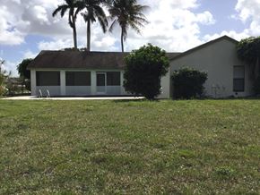 Wellington house for rent - A house with a lawn and trees in the background.