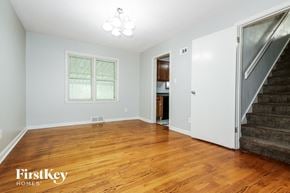 Independence house for rent - A room with wooden floors and a staircase leading to another room.