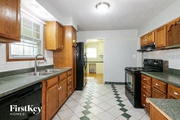 Independence house for rent - A kitchen with wooden cabinets and black appliances.