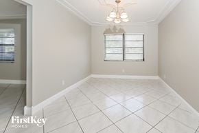 Wellington house for rent - an empty dining room with white tile flooring and a window