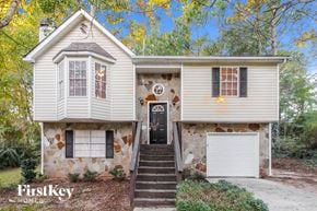 Lithonia house for rent - a white house with a black door and a white garage door