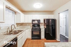 Lithonia house for rent - a kitchen with black appliances and white cabinets