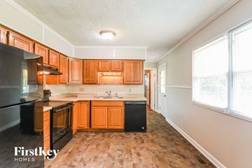Indianapolis house for rent - A kitchen with wooden cabinets and black appliances.