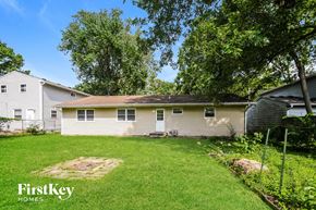 Indianapolis house for rent - A house with a lawn and trees in the background.
