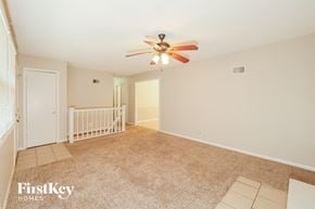 Kansas City house for rent - A spacious room with a fan and a baby gate.
